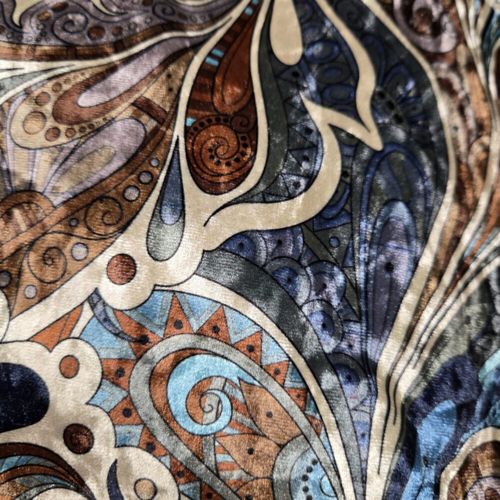 Paire de coussins à motifs abstraits cachemire/arabesques aux couleurs vives : marron terre, bronze, bleu marine et bleu clair. Tissu riche et texturé.