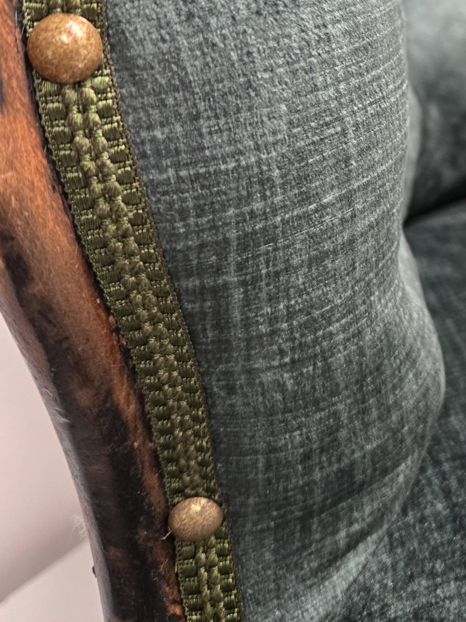 détail du galon plat vert avec les clous espacés sur le fauteuil crapaud