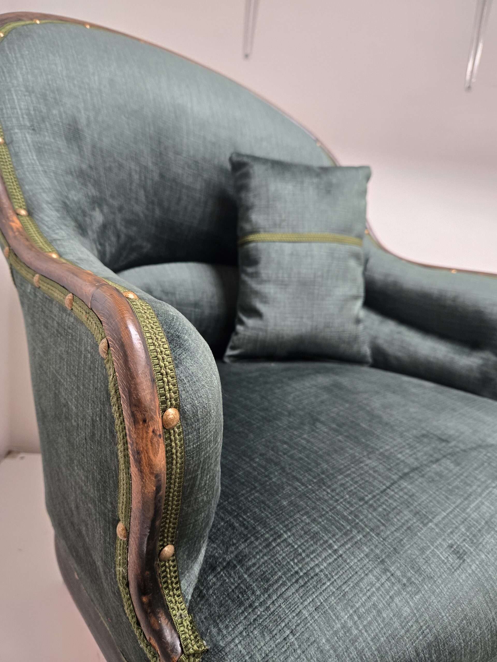 vue de cote du fauteuil crapaud vert bouteil pour présenter le travail des clous et on apercoit un coussin assorti